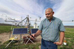 Oregon state legislator and alfalfa farmer Mark Owens looks at his cellphone for ET data, which he has used to design more efficient irrigation systems that reduced applied water by up to 25% and electricity costs by up to 20%.