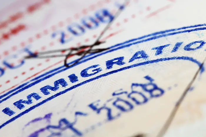 An image of a passport stamp that reads "immigration."